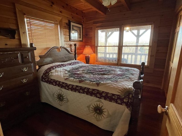 bedroom featuring wood walls and beam ceiling