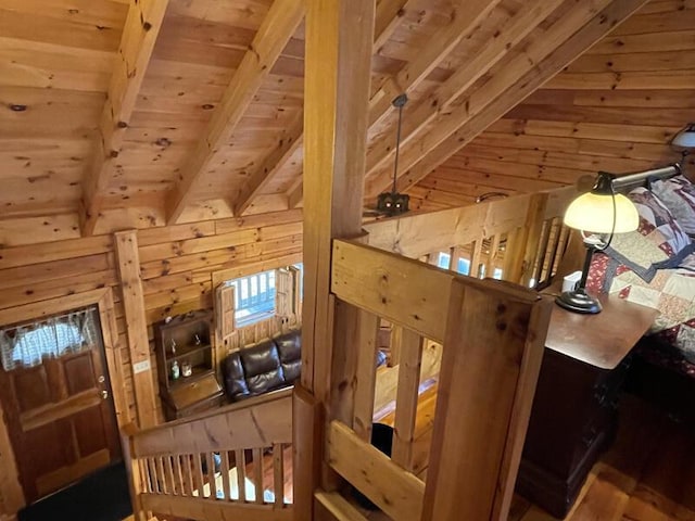 interior space with lofted ceiling with beams, wood walls, and wooden ceiling