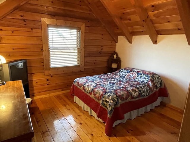 bedroom with lofted ceiling with beams, wood ceiling, light wood-style flooring, and wooden walls