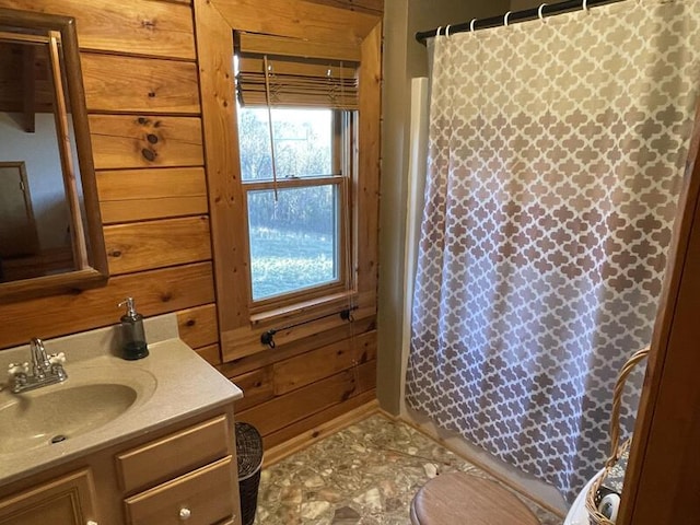 bathroom featuring curtained shower, wood walls, and vanity