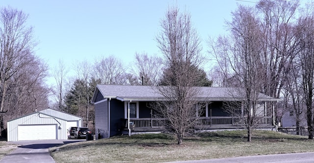 ranch-style house featuring a garage, an outbuilding, covered porch, and a shingled roof