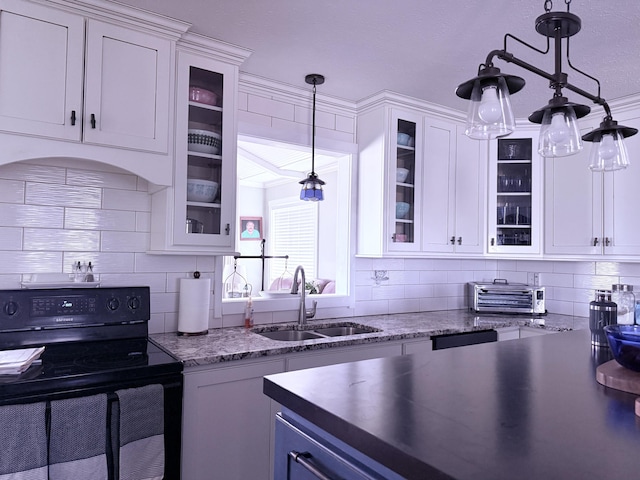 kitchen featuring electric range, a sink, hanging light fixtures, white cabinetry, and backsplash