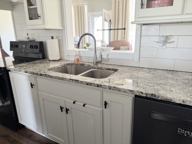 kitchen featuring range with electric cooktop, glass insert cabinets, decorative backsplash, white cabinets, and a sink