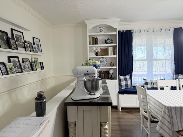 dining space featuring dark wood-type flooring, ornamental molding, and a textured ceiling