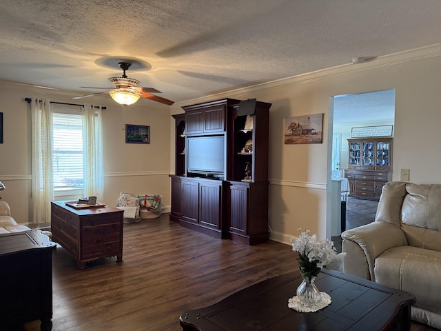 living room featuring a textured ceiling, crown molding, baseboards, ceiling fan, and dark wood-style flooring