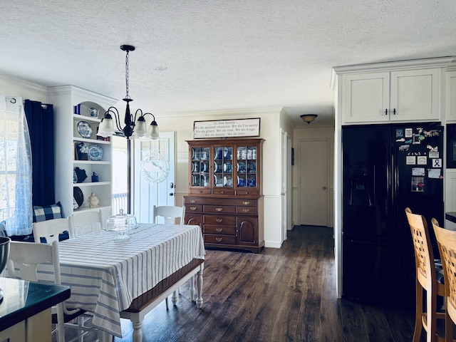 dining room featuring a textured ceiling, an inviting chandelier, dark wood-style floors, and crown molding