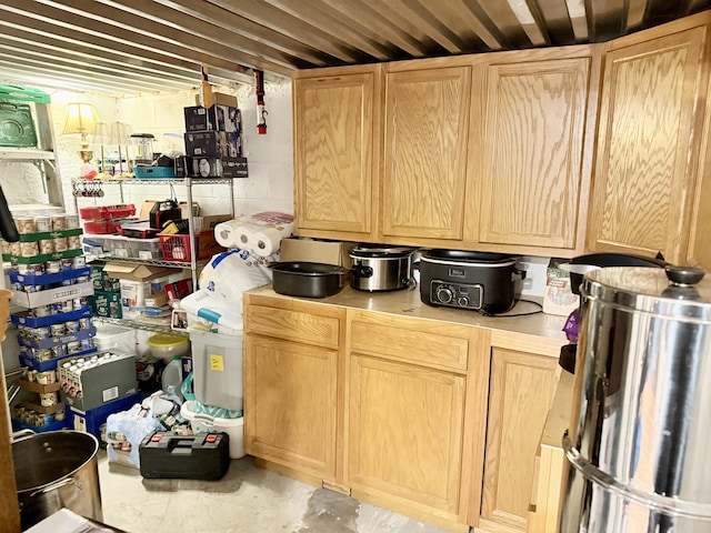 kitchen featuring light brown cabinets, light countertops, and concrete flooring