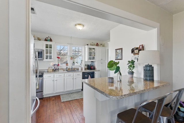 kitchen with glass insert cabinets, stove, dark wood-type flooring, and stainless steel microwave