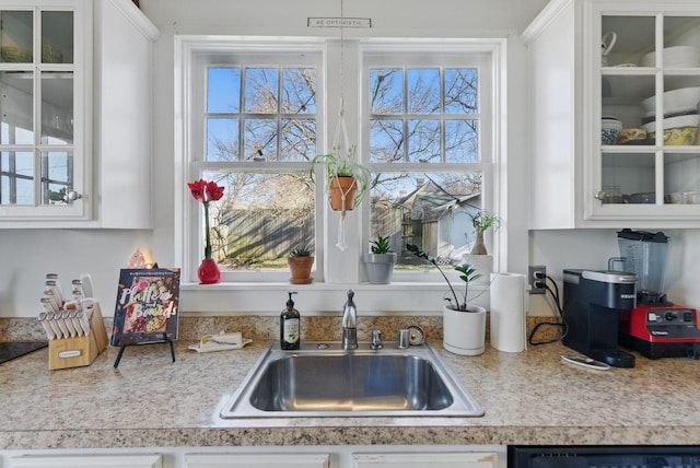kitchen featuring a sink, white cabinetry, and a healthy amount of sunlight