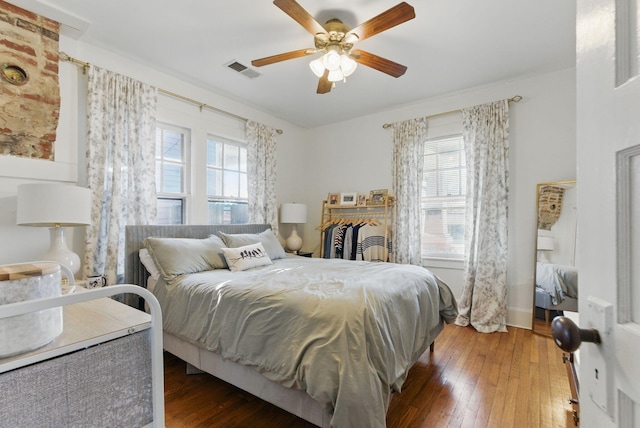 bedroom with ceiling fan, hardwood / wood-style floors, and visible vents