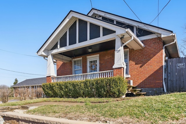 view of front of home with brick siding and a porch