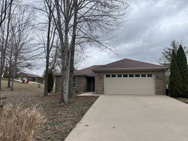 ranch-style house featuring an attached garage, concrete driveway, and brick siding