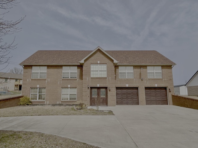 view of front of property featuring brick siding, driveway, an attached garage, and roof with shingles