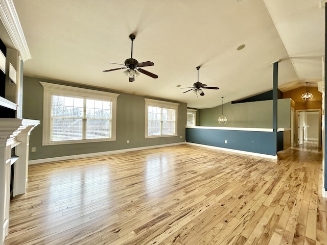 unfurnished living room with lofted ceiling, hardwood / wood-style floors, ceiling fan with notable chandelier, and a fireplace