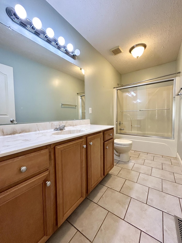 full bath with visible vents, toilet, combined bath / shower with glass door, a textured ceiling, and vanity