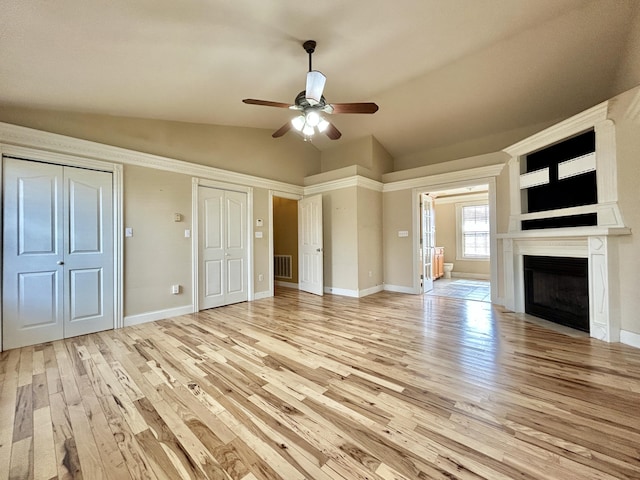 unfurnished living room featuring a fireplace, visible vents, light wood-style flooring, vaulted ceiling, and baseboards