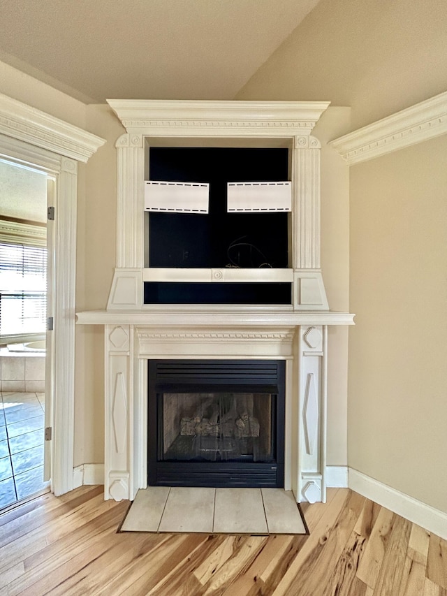 room details with a fireplace, baseboards, and wood finished floors