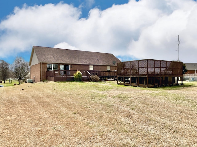 back of house with a yard, brick siding, central AC, and a wooden deck