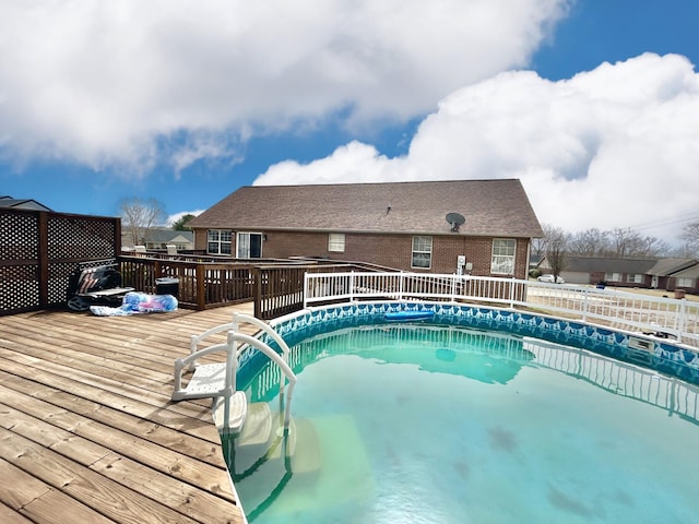 view of pool with a fenced in pool and a deck