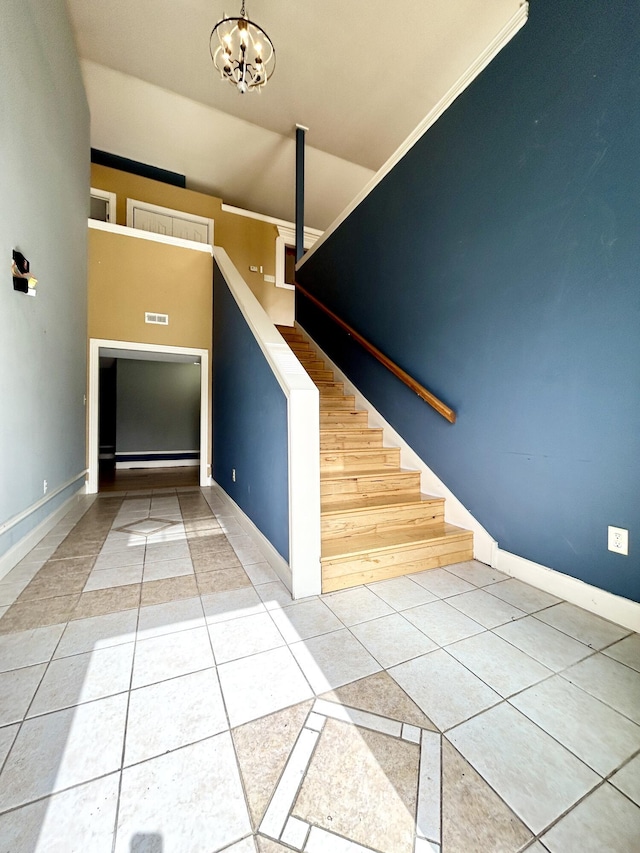 staircase featuring baseboards, a chandelier, and tile patterned floors