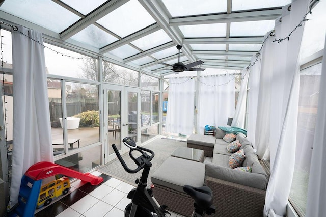 exercise room with ceiling fan, a wall of windows, tile patterned flooring, and a sunroom