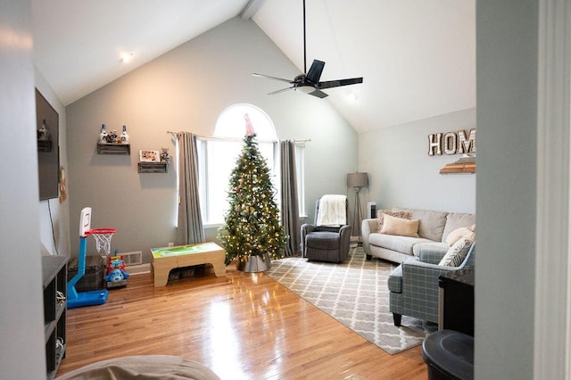 living area featuring visible vents, ceiling fan, wood finished floors, high vaulted ceiling, and beam ceiling