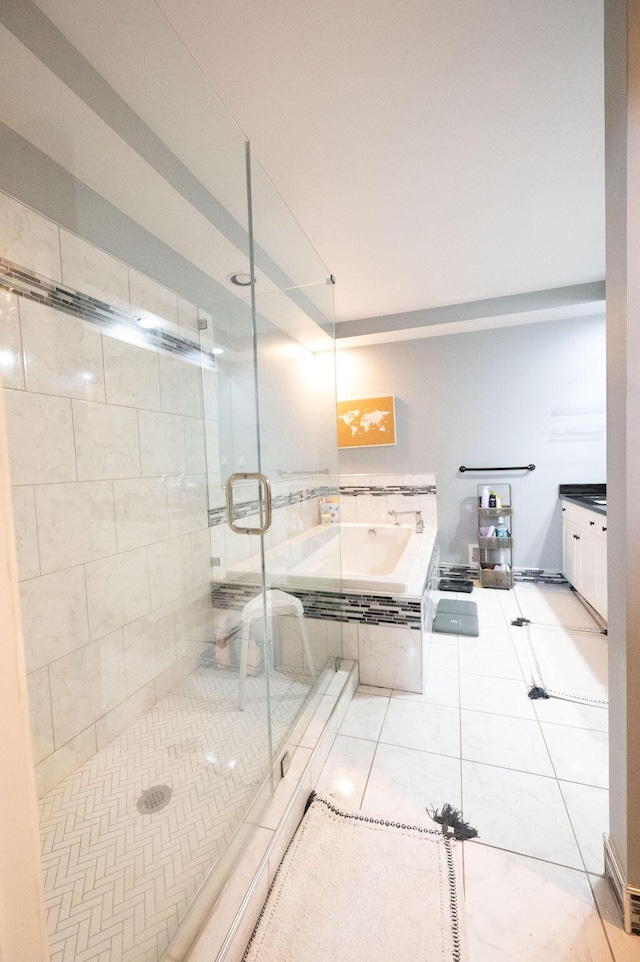 bathroom featuring tile patterned flooring, a shower stall, and a bath