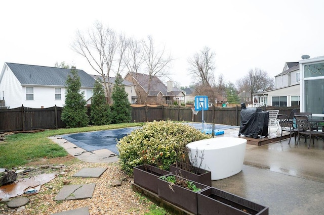 view of pool with a fenced in pool, a fenced backyard, a patio area, a residential view, and a garden