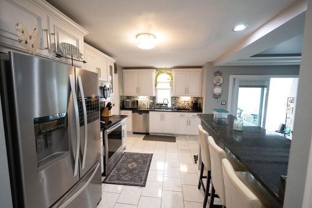 kitchen featuring light tile patterned floors, recessed lighting, stainless steel appliances, white cabinets, and tasteful backsplash