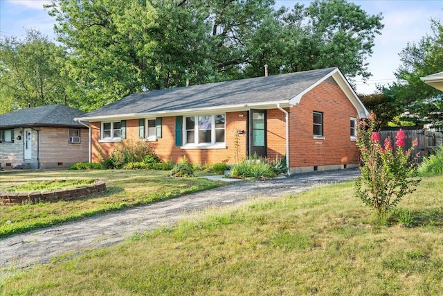 ranch-style home featuring driveway, a front yard, fence, and brick siding