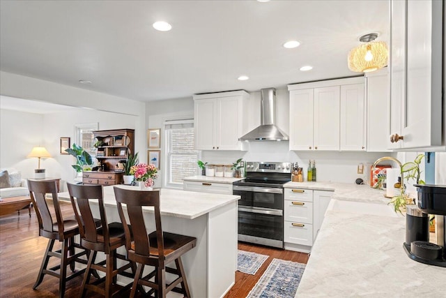 kitchen featuring a sink, white cabinetry, wall chimney range hood, double oven range, and dark wood-style floors