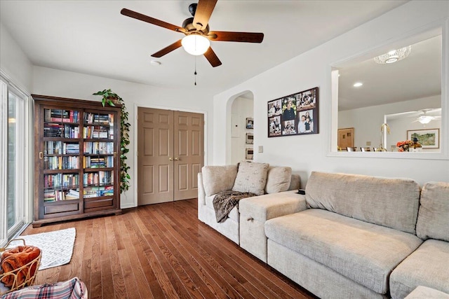 living room featuring arched walkways, ceiling fan, and hardwood / wood-style flooring