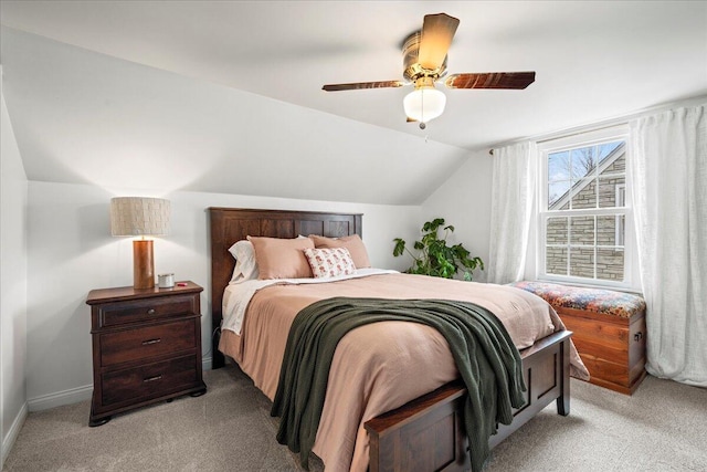 bedroom with baseboards, vaulted ceiling, a ceiling fan, and light colored carpet