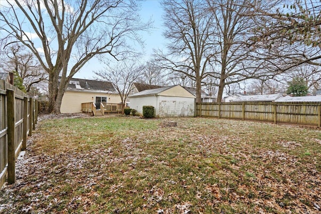 view of yard with a fenced backyard, a deck, and an outdoor structure