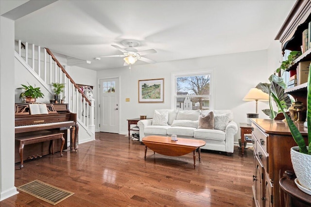 living room featuring visible vents, baseboards, a ceiling fan, wood finished floors, and stairs