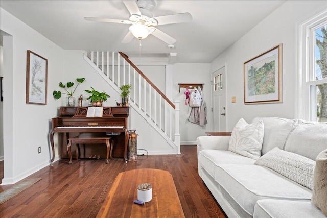 living area with baseboards, stairway, and wood finished floors