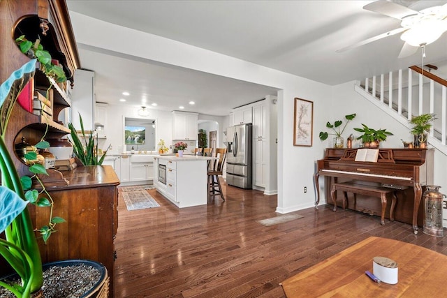 living room featuring baseboards, stairway, dark wood finished floors, and recessed lighting