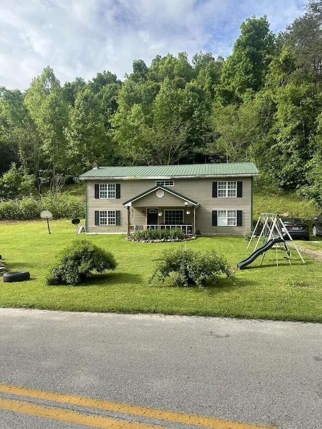 bi-level home featuring metal roof and a front lawn