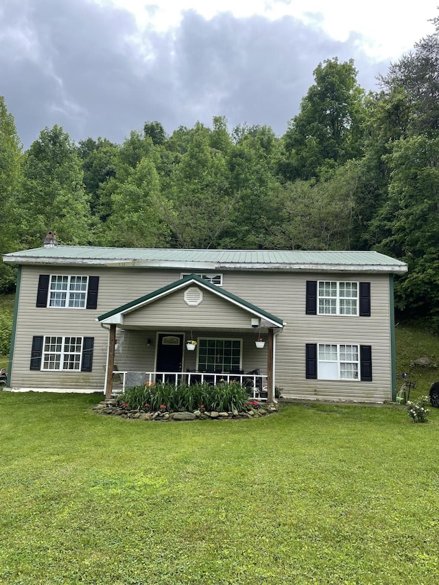 view of front of house featuring metal roof, a porch, and a front lawn