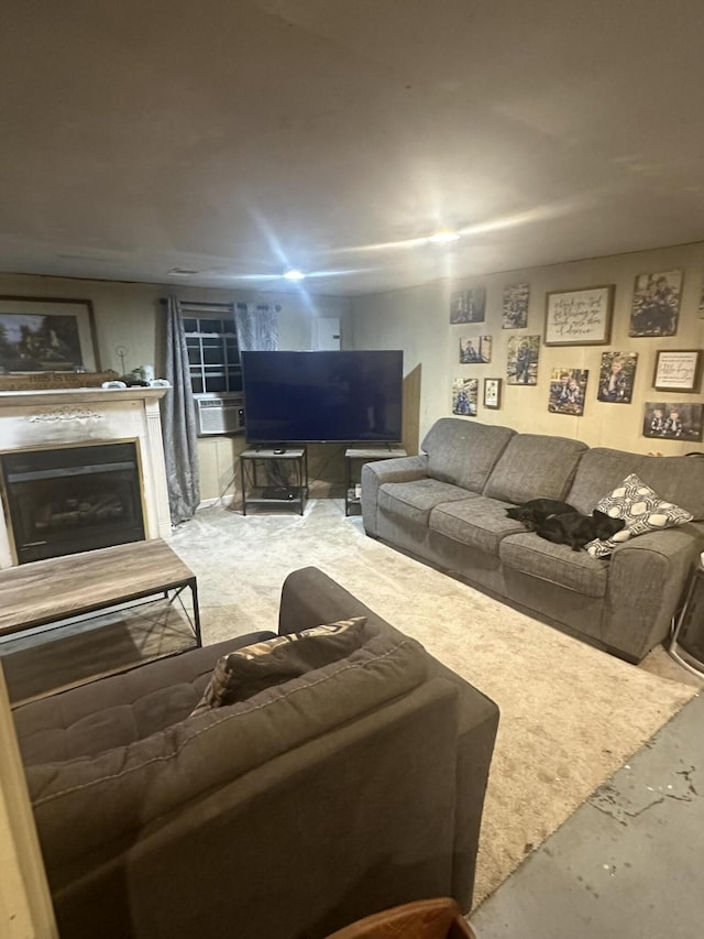 living area with unfinished concrete floors, cooling unit, and a glass covered fireplace