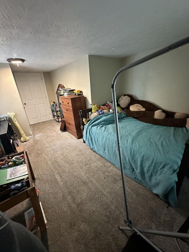 bedroom with carpet and a textured ceiling