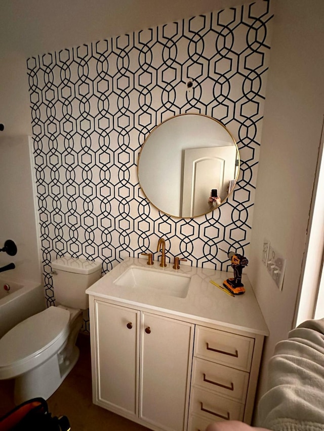 bathroom with toilet, vanity, and decorative backsplash