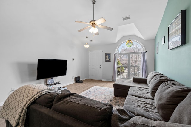 living room with lofted ceiling, visible vents, a ceiling fan, light wood-type flooring, and baseboards