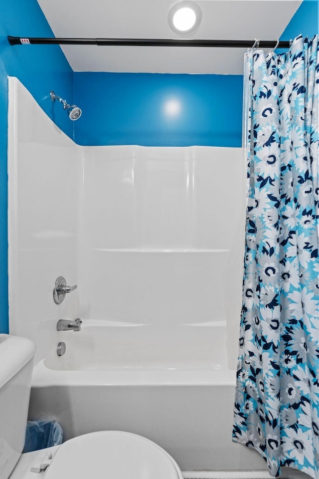 bathroom with shower / bath combo with shower curtain and toilet