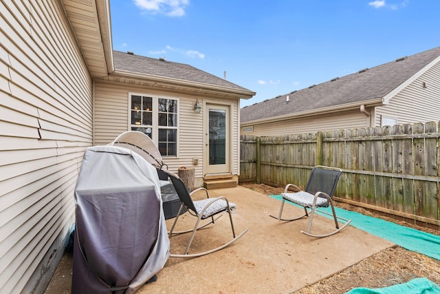 view of patio featuring entry steps, fence, and a grill