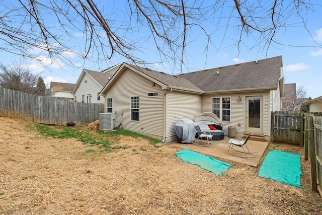 back of house featuring a fenced backyard, cooling unit, roof with shingles, a lawn, and a patio area