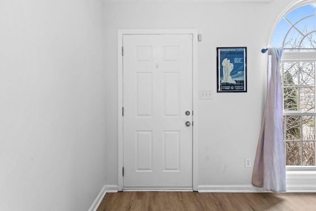 doorway featuring wood finished floors and baseboards