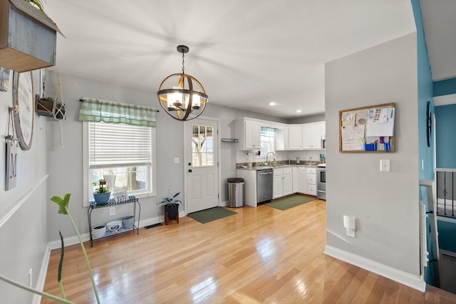 entrance foyer featuring recessed lighting, an inviting chandelier, light wood-style flooring, and baseboards