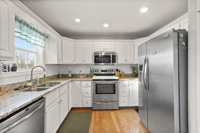 kitchen featuring appliances with stainless steel finishes, a sink, and white cabinets