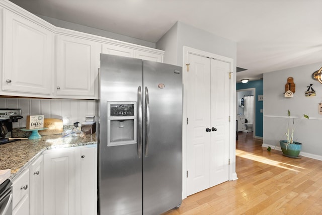 kitchen with baseboards, white cabinets, stainless steel fridge with ice dispenser, light wood-type flooring, and light stone countertops